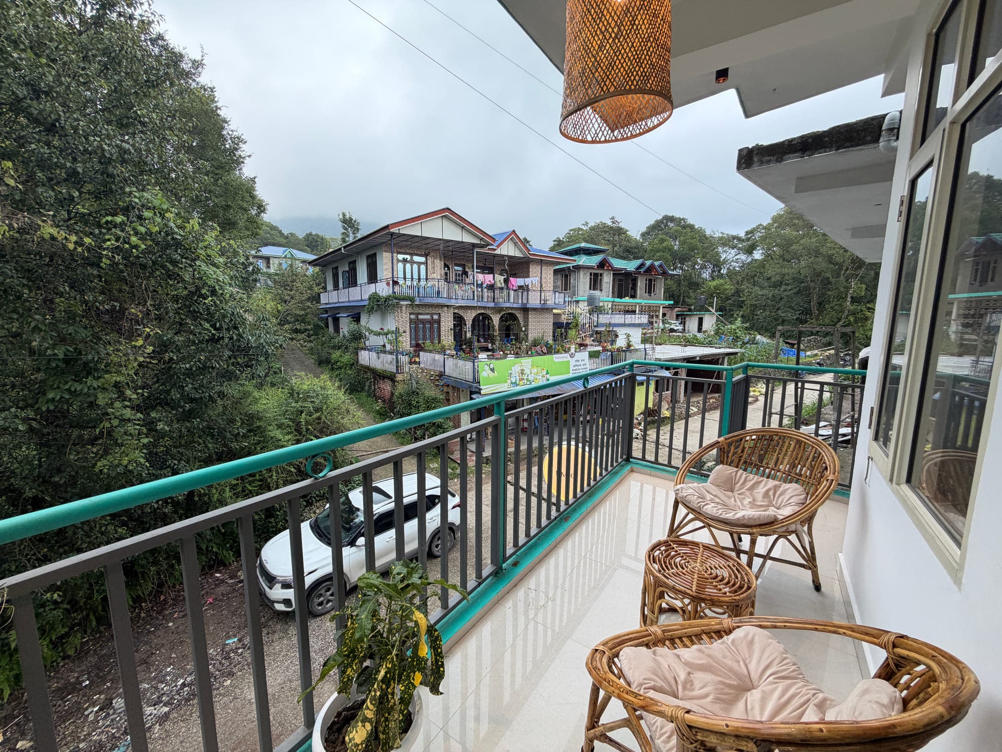 View from a balcony at Dimora Homes over Chougan village and forested hills in Bir