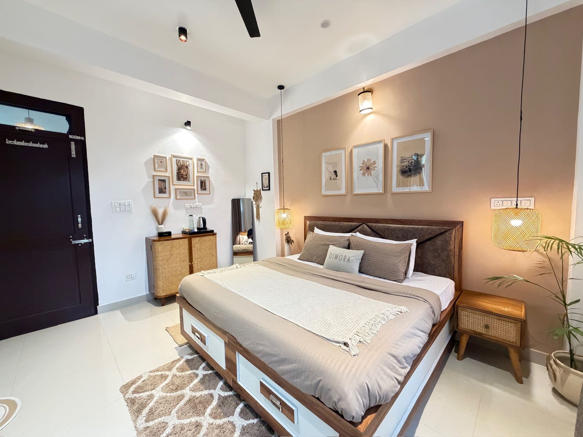 Deluxe King room with balcony at Dimora Homes, Bir - king bed, framed prints and a cane sideboard